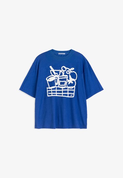 T-shirt bleu à manches courtes avec un dessin en ligne blanche représentant un panier contenant des articles de cuisine comme des tasses, des ustensiles et des fruits.