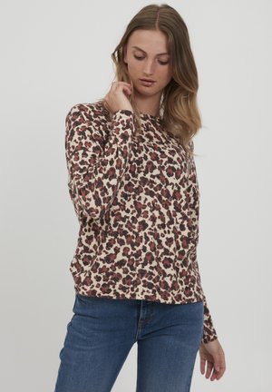 Lange mouwen, ronde hals top in beige met een rood en zwart luipaardmotief. Zachte, rekbare stof met een relaxed fit en manchet mouwen.