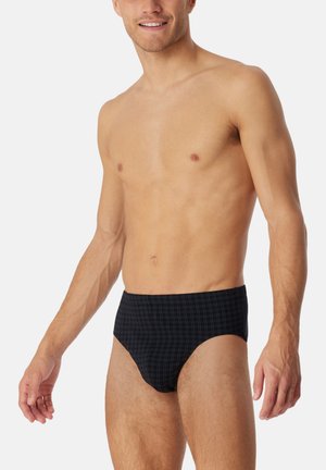 Slips de bain navy avec un motif en grille, fabriqués à partir d'un tissu lisse, présentant un design ajusté et une ceinture confortable.