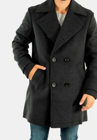 Abrigo peacoat de lana gris oscuro con diseño cruzado, solapas grandes, dos bolsillos delanteros y botones negros. Tejido texturizado.