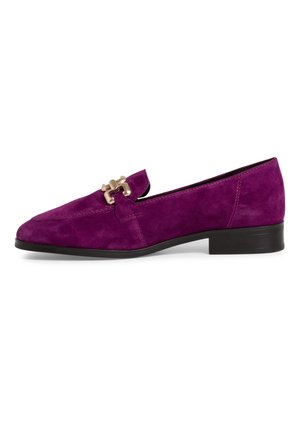 Paarse suède loafer met een lage zwarte hak, voorzien van een decoratief hardwareaccent in goudkleur aan de voorkant en gestikte details.