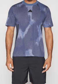 Herrarnas sport-t-shirt i blått, med en texturerad design, rund hals, korta ärmar och svarta accenter på sidorna samt logotyp på bröstet.