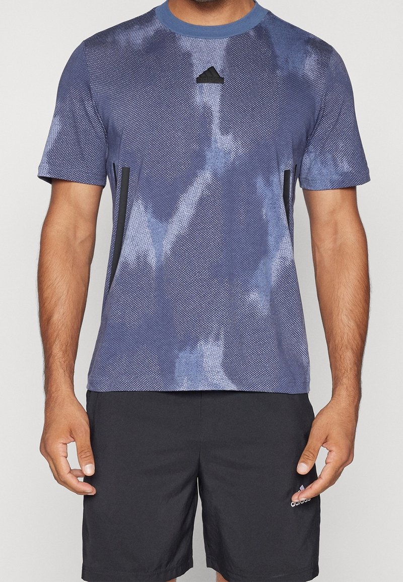 Herrarnas sport-t-shirt i blått, med en texturerad design, rund hals, korta ärmar och svarta accenter på sidorna samt logotyp på bröstet.