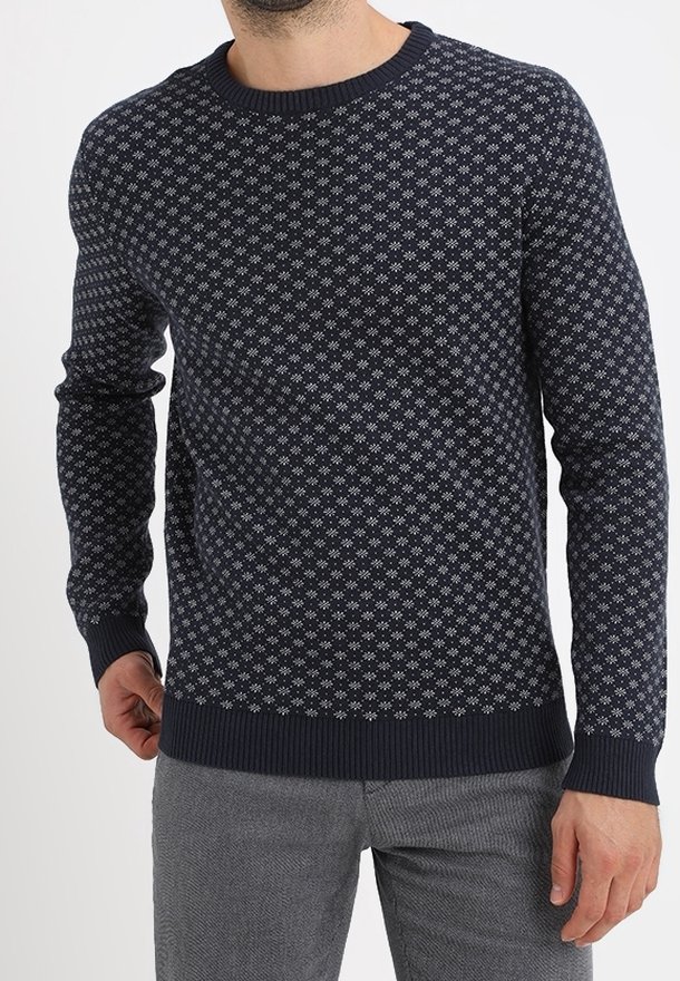 Navy blue knitted sweater featuring a geometric white pattern, round neck, and ribbed cuffs and hem. Warm and textured fabric.