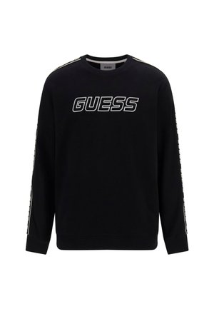 Zwarte sweatshirt met lange mouwen, voorzien van een vet wit "GUESS" logo op de voorkant en gestreepte details langs de mouwen.