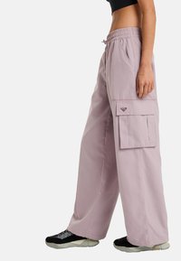 Light pink cargo pants with an elastic waistband and a side pocket. Made from a lightweight material, featuring a relaxed fit and straight legs.