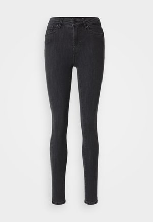 Black skinny jeans made from denim. Features a high waist, zipper fly with button closure, and five pockets. Smooth texture, no embellishments.