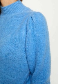 Maglione azzurro chiaro lavorato a maglia con colletto alto a coste, caratterizzato da maniche a palloncino e una finitura morbida e texture.