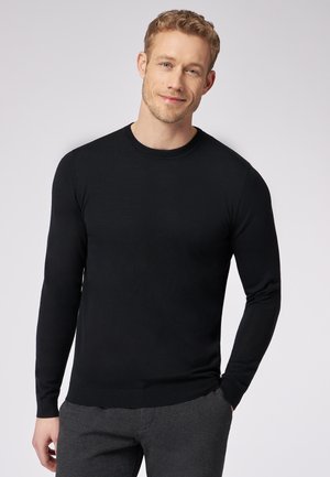 Sort, langærmet, crew-neck striktrøje med en glat tekstur og tætsiddende design, parret med grå bukser.