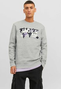 Sudadera gris con un diseño gráfico que incluye el texto "JACK & JONES". El diseño presenta un motivo de mapa mundial con acentos en negro y morado.