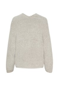 Beige stickad tröja med v-ringning, långa ärmar och en lös passform. Texturen är mjuk och fluffig med ribbade kanter vid nederkant och ärmslut.