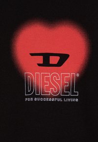 Čierne tričko s grafickým prvkom červeného srdca s prechodovým efektom, na ktorom je v tučných bielych písmenách napísané "DIESEL" a pod ním "PRE ÚSPEŠNÝ ŽIVOT".