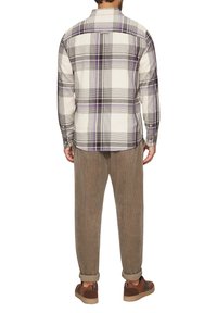 Langsleeve geruiten overhemd in beige met paarse en zwarte lijnen, gecombineerd met lichtbruine corduroy broek, met een ontspannen pasvorm en opgerolde manchetten.