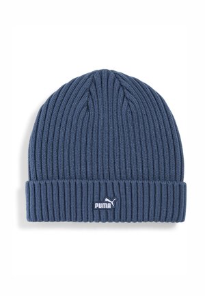 Blauwe gebreide beanie met geribbelde textuur en omgeslagen rand. Voorzien van een wit Puma-logo aan de voorkant. Gemaakt van zacht, rekbaar materiaal.