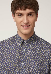 Blauw bloemenpatroon overhemd met een button-down kraag en lichtgewicht stof, voorzien van witte knopen en kleine geborduurde details op de borst.