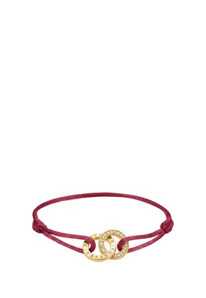 Bracciale sottile in corda rosa scuro con due anelli d’oro intrecciati, uno decorato con piccoli cristalli e testo inciso intorno ai bordi.