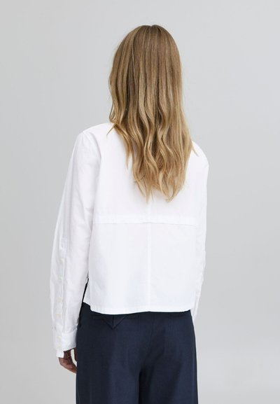 Weißes, kurzes Hemd mit Knöpfen und langen Ärmeln, mit geradem Saum und glatter Textur. Die Rückansicht zeigt ein schlichtes Design ohne Muster.