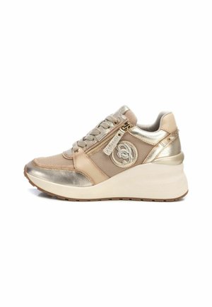 Zapatillas cuña en dorado metálico y beige; cuentan con tejido de malla, cremallera decorativa, detalle del logo y acentos laterales texturizados.