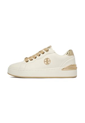 Biały sneaker na platformie z złotymi przelotkami, sznurówkami wstążkowymi, akcentem na pięcie i okrągłym złotym logo po boku.