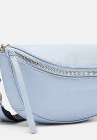 Błękitna skórzana torebka crossbody o zaokrąglonym kształcie, z detalami w srebrnym kolorze, zamkiem błyskawicznym oraz wytłoczonym logo. Gładka faktura z pojedynczym paskiem.