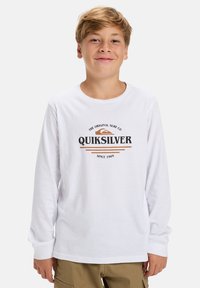 Witte longsleeve T-shirt met het Quiksilver-logo in zwart en bruin. Het shirt heeft een ronde hals en ribgebreide manchetten.