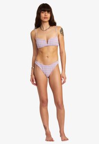 Pink und weiß karierter Bikini, bestehend aus einem Bralette-Oberteil mit dünnen Trägern und niedrighüftigem Höschen. Glattes, leichtes Material.