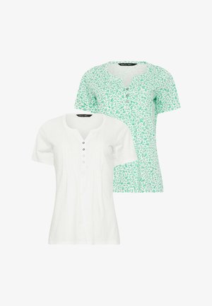 Twee dames tops met korte mouwen, één effen wit met knopen, één wit met een groen bladerenpatroon en knopen, beide met een ronde halslijn.