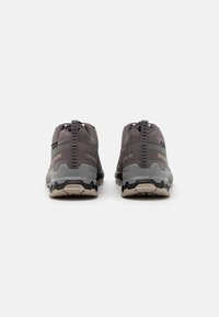 Gray hiking shoes featuring a textured fabric upper, rubber accents, a cushioned midsole, and a rugged outsole for traction.