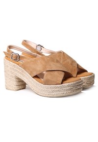 Svetlo smeđe suede platform sandale s remenom oko pete, s pletenim jutenim detaljem, s ukriženim trakama i podesivim kopčanjem oko gležnja.