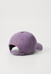 Purple cotton baseball cap featuring a curved brim and adjustable back strap, with a textured finish and embroidered eyelets for ventilation.