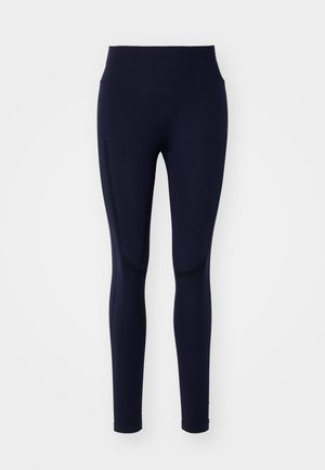 Leggings azul marinho feitos de um tecido elástico. Cintura alta, textura suave e detalhes sutis nos painéis laterais. Design ajustado ao corpo.