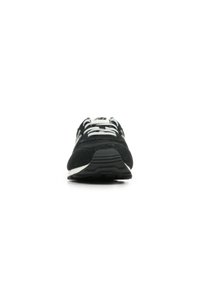 Scarpa da atletica nera con tomaia in suede, lacci bianchi e suola in gomma. Presenta un design elegante e una leggera elevazione del tacco.