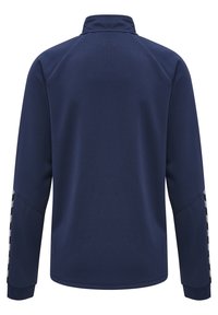 Marinblå tröja i form av jacka med hög krage, strukturerad tyg, och svarta och vita accentränder på ärmarna. Fullständig bakvy.