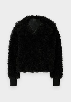 Veste noire courte en tissu texturé à finition duveteuse, avec un profond décolleté en V et des poignets côtelés. Caractéristiques d'une apparence douce et volumineuse.