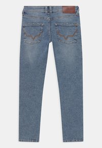 Blå denimjeans med slim fit, två bakfickor med bruna sömnadsdetaljer och en brun konstläderetikett i midjan.