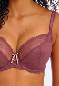 Lace bra in mauve with floral pattern, underwired support, adjustable straps, and a small decorative bow at the center.