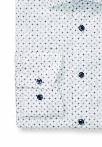 Weißes Hemd mit kleinem marineblauen Blumenmuster, ausgestattet mit zwei dunklen Knöpfen an den Manschetten und am Kragen. Glattes Material, klassisches Design.