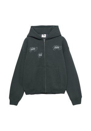 Tamnozelena majica s kapuljačom na patentni zatvarač, izrađena od mekanog materijala. Ima veliki prednji džep i bijele grafičke otiske na prsima i rukavima.