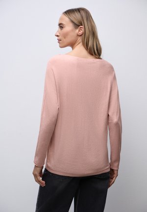 Suéter de manga larga, rosa claro, en un tejido suave y texturizado. Cuello redondo, ajuste holgado, con un dobladillo curvado en la parte posterior.