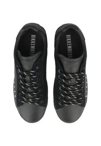 Svarta sneakers med en slät läderovandel, rund tå, texturerade accenter och vita snören med svarta ränder, märkesinlägg.