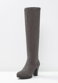 Bota de ante gris hasta la rodilla con puntera redonda, tacón alto y textura suave. Presenta un cañón sin costuras y una suela de goma resistente.