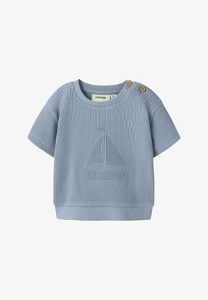 Vaaleansininen vauvan paita, jossa on lyhyet hihat, puiset napit olkapäällä ja purjevene-kuvio edessä.