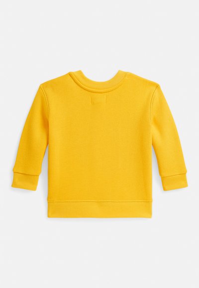 Dzeltena kokvilnas džemperis, apaļa izgriezuma kakls, garas piedurknes ar ribotām aprocēm, vienkrāsains, gluda tekstūra un kārtīgi šuvumi gar apakšiņu.