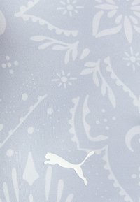 Tecido atlético azul claro com um padrão floral subtil e um logótipo branco da Puma no canto inferior. Textura suave, design ajustado.