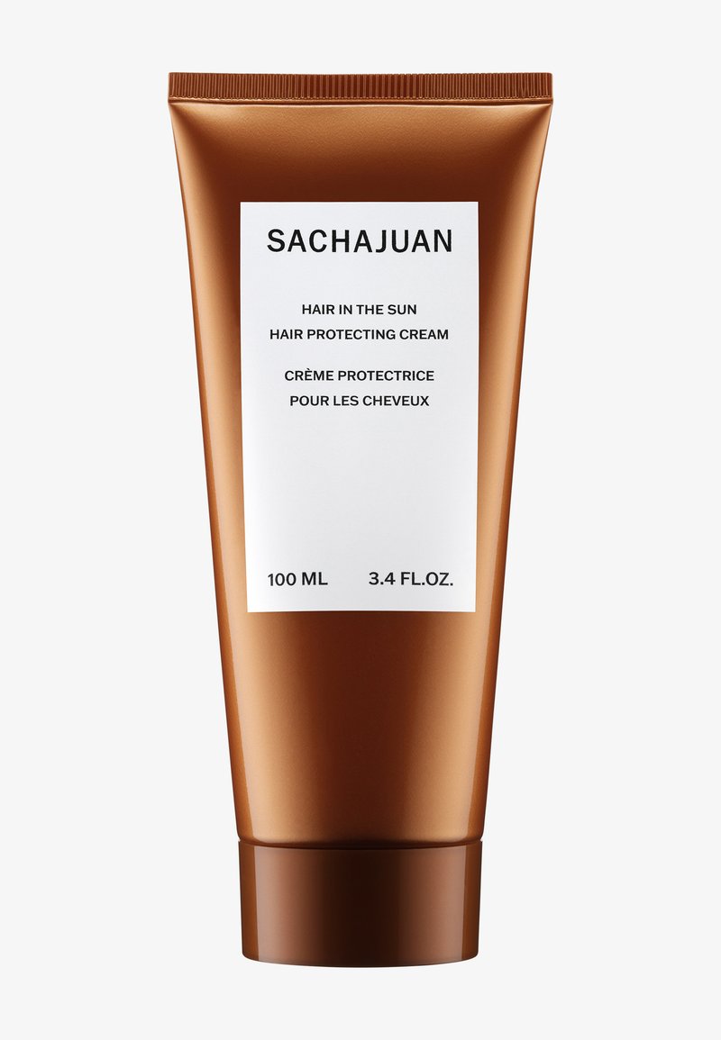 SACHAJUAN hårbeskyttende krem i en bronsefarget tube. Etiketten har svart tekst på hvit bakgrunn, med produktdetaljer på både engelsk og fransk.