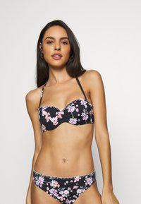 Virágmintás bikini szett, fekete anyaggal, rózsaszín és lila virágokkal. A melltartó merevített, alátámasztott kialakítású; a bugyi alacsony derekú.