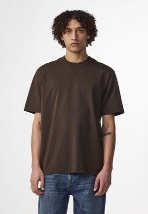 Bruine katoenen crewneck t-shirt, korte mouwen, relaxte pasvorm, gladde textuur, met een ronde hals, gedragen met blauwe spijkerbroek.