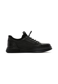 Black sneakers made of textured leather and smooth material, featuring a lace-up design, padded collar, and a thick rubber sole.