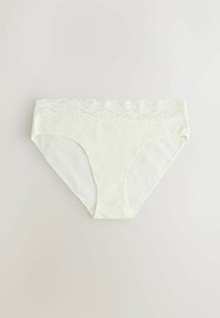Białe damskie majtki z koronkową lamówką przy pasie, rozłożone na płasko na jasnym tle.