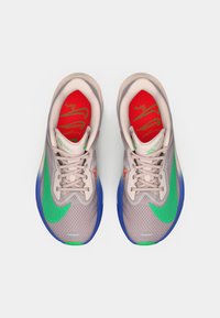 Αθλητικά παπούτσια με ανοιχτό γκρι διχτυωτό άνω μέρος, ζωντανές πράσινες και κόκκινες λεπτομέρειες, μπλε καουτσούκ σόλα και επίπεδες κορδόνια με μαξιλαρωμένο γιακά.